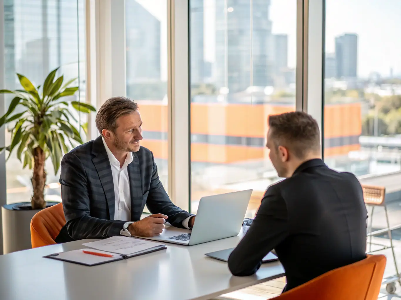 A person confidently participating in a mock interview session, receiving constructive feedback from a career coach. The setting is a modern office environment.